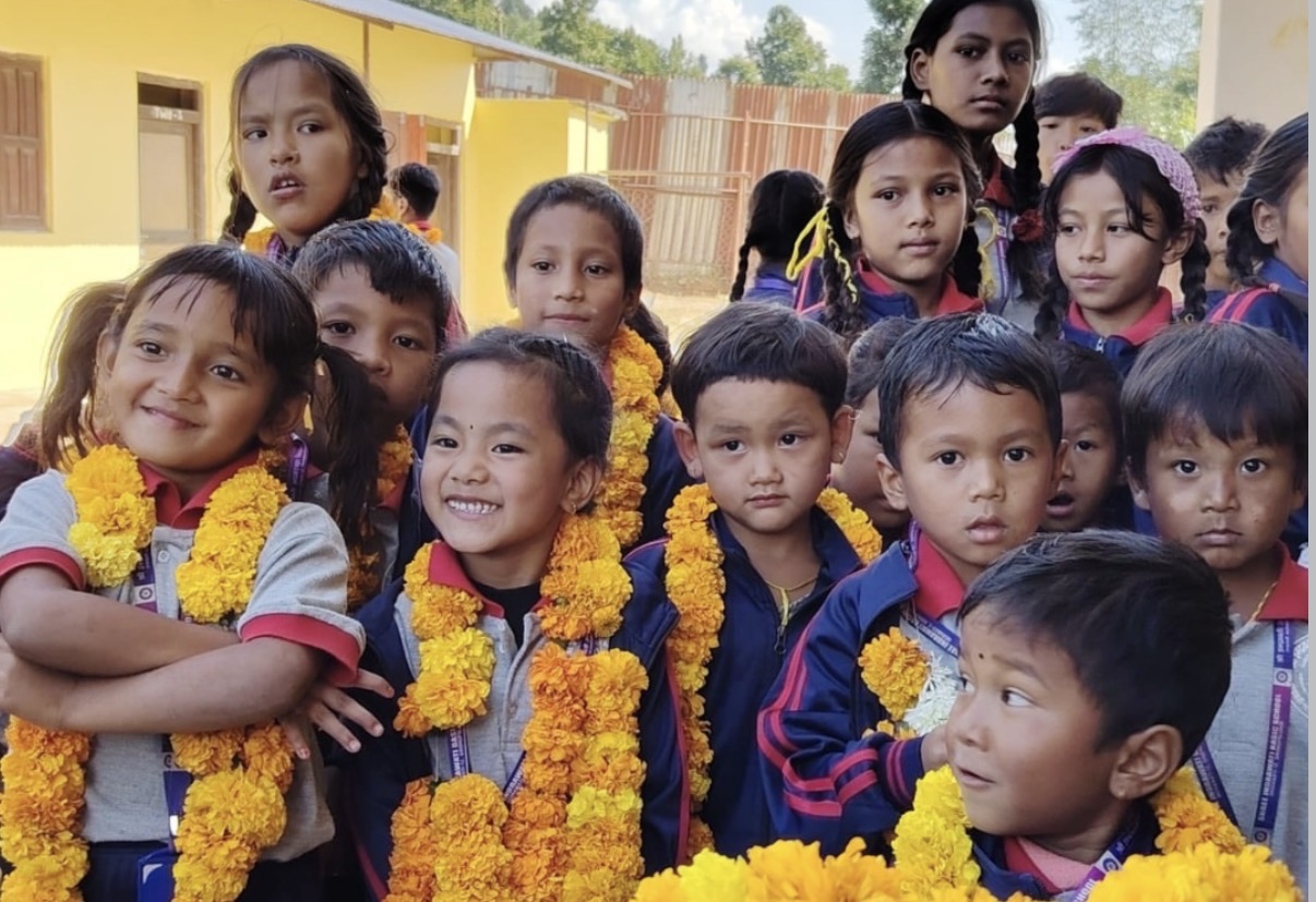 Children at a partner school in Indrawati, wearing marigold garlands at a school-day welcome