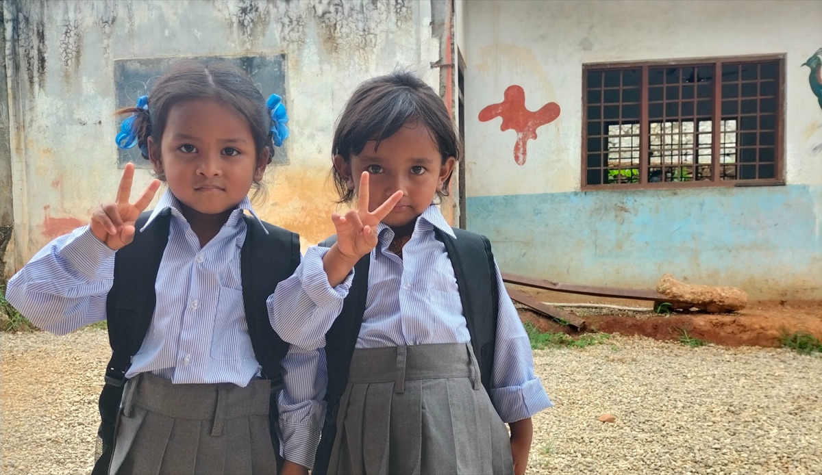 Two students in uniform at the Sipapokhare Ward 7 tuition centre, posing for the camera in the schoolyard.